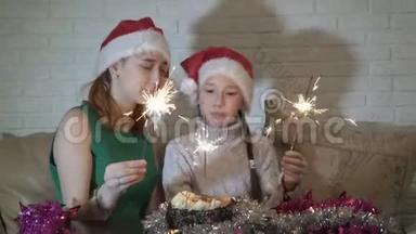 幸福的家庭，两个女孩，一个小女孩和一个戴着<strong>圣诞老人</strong>帽子的少年，在<strong>蛋糕</strong>上放着闪亮的小星星